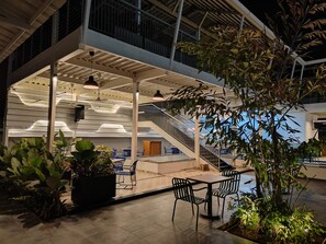 An indoor atrium with a staircase, seating area, and potted plants. - The Waves Hotel Sarjapura (Anekal)