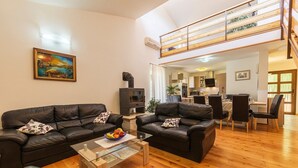 Ein Wohnzimmer mit zwei schwarzen Ledersofas, einem Glastisch und einem Gemälde an der Wand.