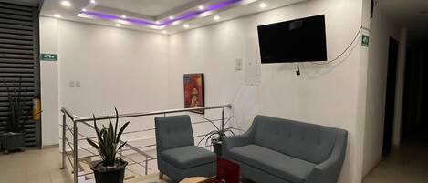 Una sala de estar moderna con un sofá gris, una mesita y una planta en maceta.
