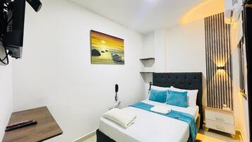 Ein Schlafzimmer mit einem Bett, einem Nachttisch und einem Bild an der Wand.
