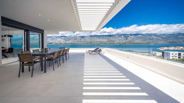 Un espace de restauration moderne offrant une vue sur un paysage montagneux et un plan d’eau.