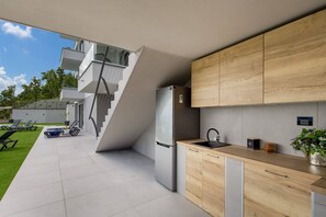 Enjoy a meal in the kitchen with a view of the surrounding greenery from the adjacent balcony.