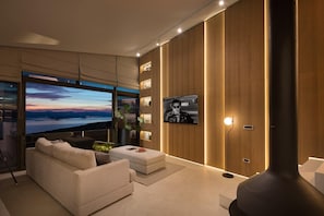 A modern living room with a large flat-screen TV, a sofa, a coffee table, and a fireplace. - Luxury & Unique Villa Bevel House with sea view, family quiet area, stylish, bbq (Donja Banda)