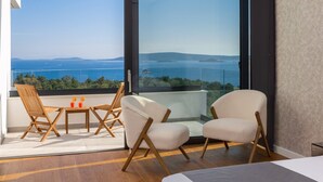 A balcony with a view of the sea, wooden chairs, a small table, and a sofa. - Luxury Villa Excellence with a pool (Seget Vranjica)