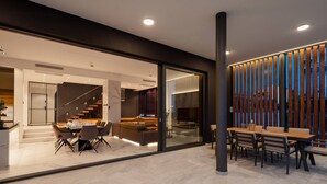 A modern interior with a dining area, a living space, and a staircase leading to an upper level. - Luxury Villa Excellence with a pool (Seget Vranjica)