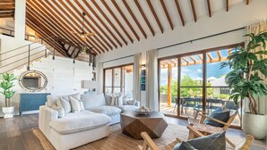 Ein großzügiger Wohnbereich mit modernem Design, ausgestattet mit einem großen Sofa, einem Couchtisch und einem Essbereich mit Sitzgelegenheiten im Freien.
