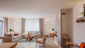 A modern living room with a sofa, coffee table, and chairs. There is a TV and a small table with a lamp. - Villa Clementine with pool, sea view, big group near sea pet friendly bbq family (Sutivan)