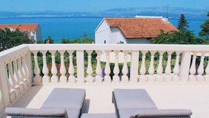 A balcony with white balustrades and two sun loungers, overlooking a coastal view with buildings and a clear sky. - Villa Clementine with pool, sea view, big group near sea pet friendly bbq family (Sutivan)