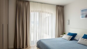 A bedroom with a bed, curtains, and a wall-mounted light fixture. - Villa Clementine with pool, sea view, big group near sea pet friendly bbq family (Sutivan)