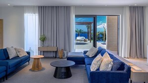 A modern living room with a blue sofa, a round coffee table, and a view of the sea through large glass doors. - Villa Crystalsea 1 infinity heatedpool in Hvar in Hvar, sauna, family, stylish, sea view (Hvar)