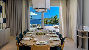 A dining area with a table set for six, overlooking a pool and ocean view. - Villa Crystalsea 1 infinity heatedpool in Hvar in Hvar, sauna, family, stylish, sea view (Hvar)