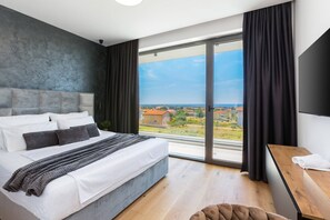A modern bedroom with a large bed, a wooden desk, and a view of the countryside. - Luxury Villa Dali - 42 m2 infinity pool & wellness, family, stylish (Medulin)
