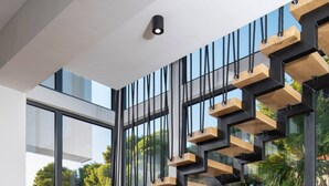 A modern staircase with wooden steps and black metal railings, leading to a glass door. - Luxury Villa Dali - 42 m2 infinity pool & wellness, family, stylish (Medulin)