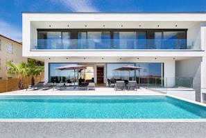 A modern two-story house with a swimming pool, outdoor seating, and large windows. - Luxury Villa Dali - 42 m2 infinity pool & wellness, family, stylish (Medulin)