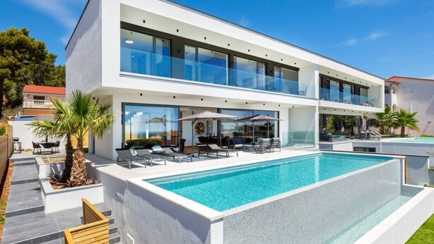 A modern two-story house with a large swimming pool, outdoor seating, and a clear view of the surrounding area. - Luxury Villa Dali - 42 m2 infinity pool & wellness, family, stylish (Medulin)