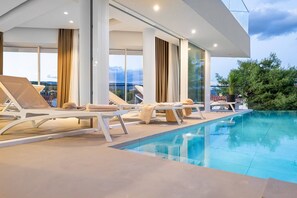 A modern outdoor pool area with lounge chairs and a clear view of the surrounding landscape. - Estate da Noi, heated indoor & outdoor pool, sea view, sauna, family, bbq (Vrboska)