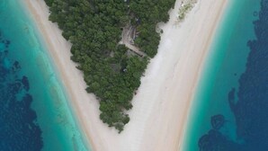 An aerial view of a narrow, elongated island with a sandy beach and dense green forest. - Villa Golden Ananas, 45 m2 headet pool, sea view (Sutivan)