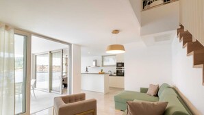 Eine moderne Wohnung mit Essbereich, Küche und einem Balkon mit Blick.