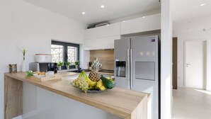 A modern kitchen with a wooden countertop, stainless steel appliances, and a view to the outside. - Excellent Villa Oasis with a pool, bbq, quiet area, family, gym (Grizane)