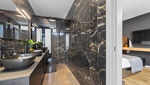 Un baño moderno con un espejo grande, dos lavamanos y suelo de madera.