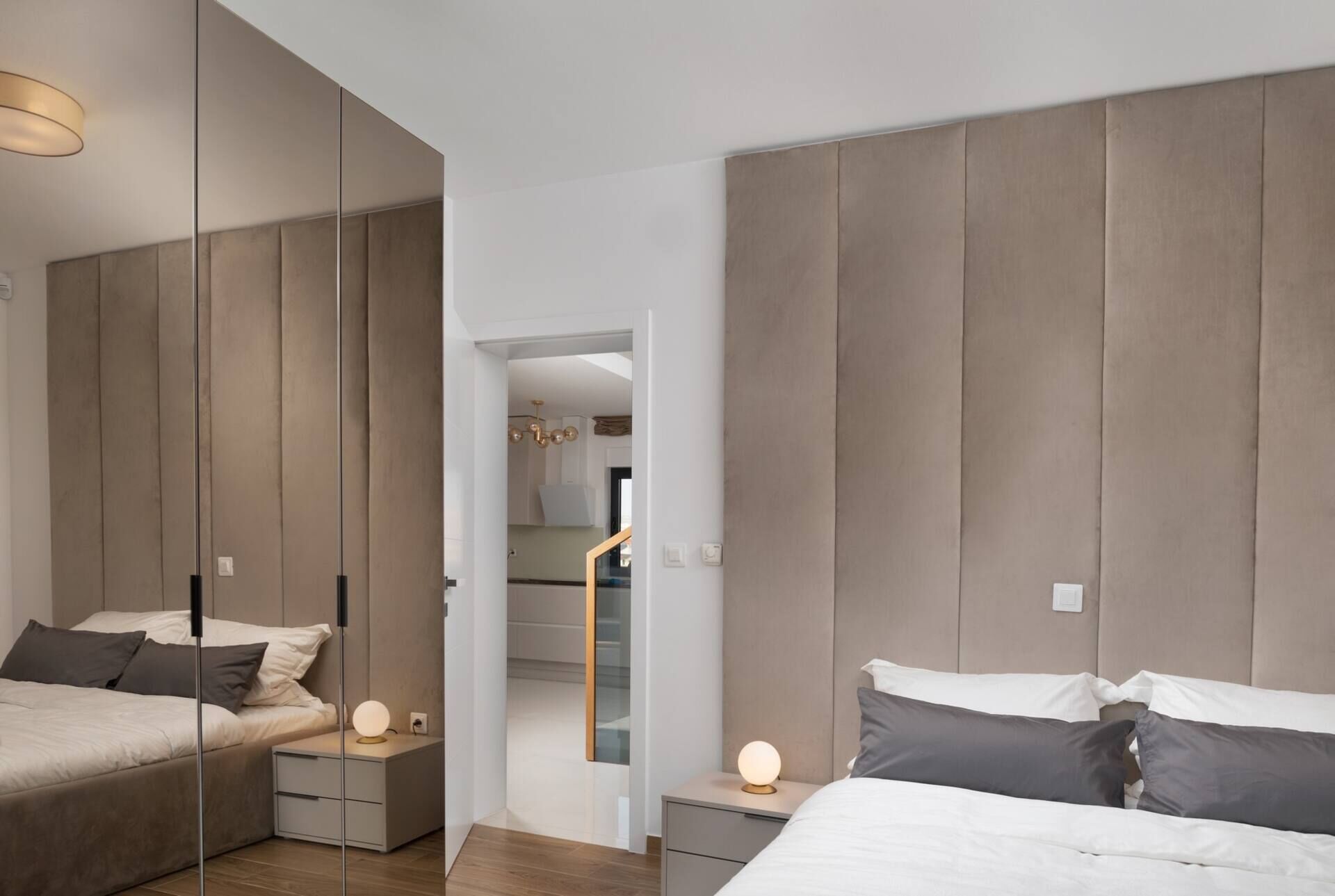 Een moderne slaapkamer met een groot bed, nachtkastjes en een kledingkast.