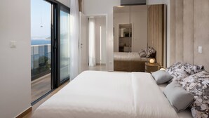Une chambre moderne avec un grand lit, une armoire et une vue sur la mer.