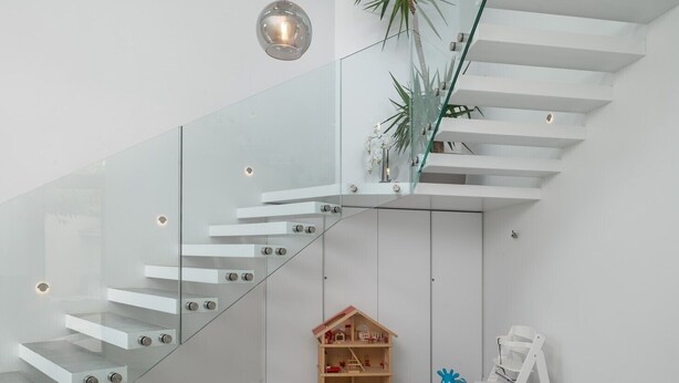 A modern interior with a glass staircase, a small wooden toy house, and a blue toy animal. - Luxury Villa Red heated pool, sauna, tennis court, mini golf, stylish, family, panoramic view (Zmijavci)