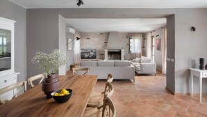 A spacious living area with a fireplace, a dining table with chairs, and a sofa. - Rustic Villa Rubus with a pool in Istri, panoramic view, pet friendly (Sveti Lovrec)