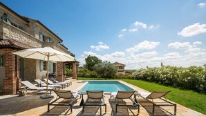 A poolside area with lounge chairs and umbrellas, a stone building, and a clear blue sky. - Rustic Villa Ruta with a pool in Istri, panoramic view, pet friendly, quite area, family, private parking, terrace, fancy yard (Sveti Lovrec)