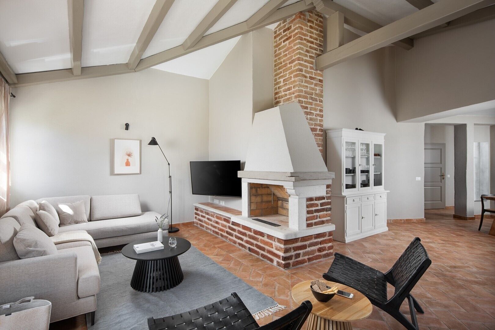 A living room with a fireplace, a sofa, a TV, and a cabinet.