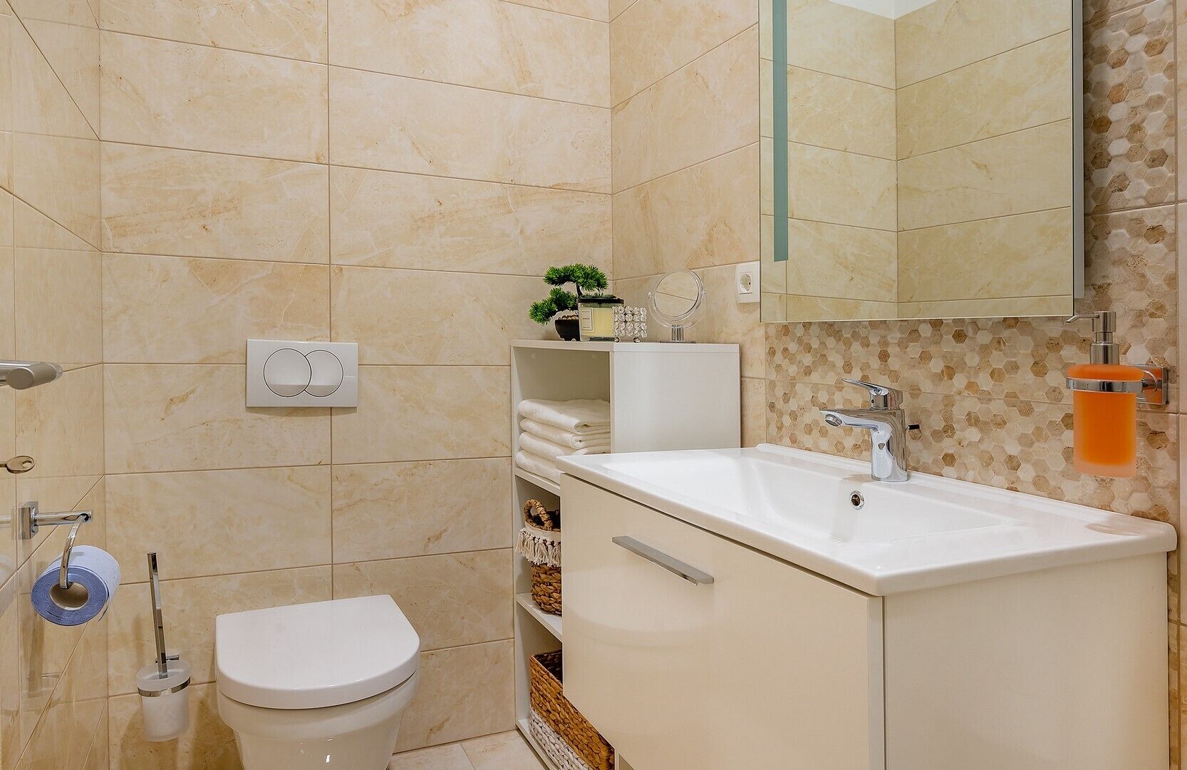 A bathroom with a white sink, a toilet, and a mirror.