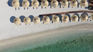 A beachside area with rows of beach umbrellas and lounge chairs. - Exclusive Villa Marnano - Split, sea view, near center, concierge services, jacuzzi (Split)