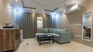 Un salon moderne avec un canapé, une table basse, un meuble et une fenêtre avec des rideaux.