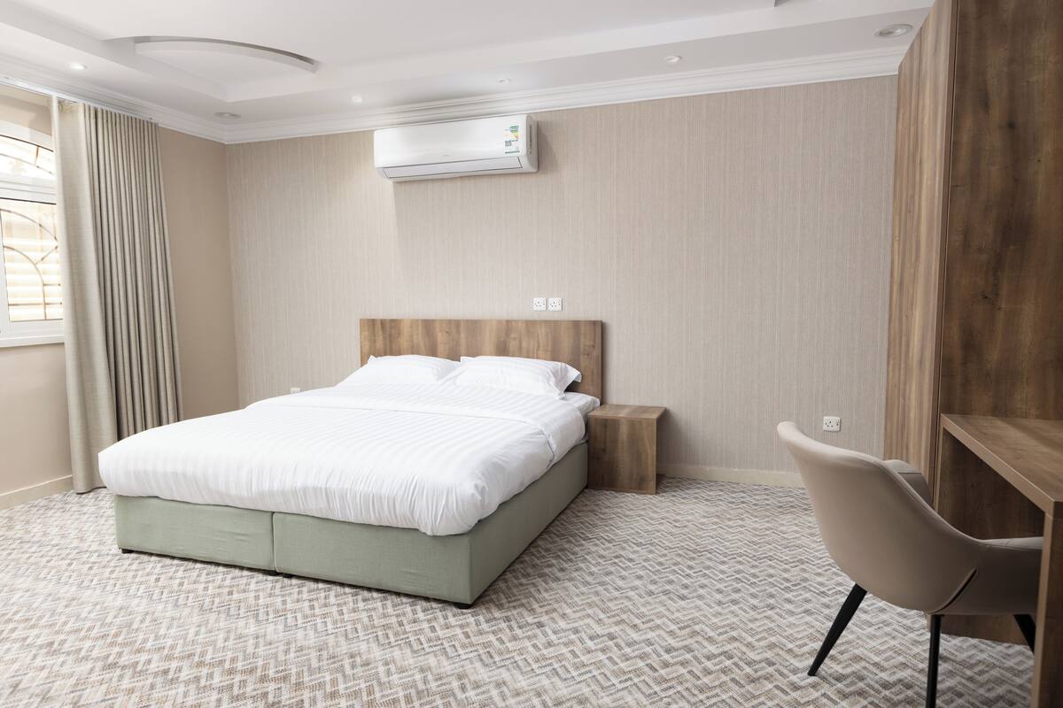 Une chambre d’hôtel équipée d’un lit, d’un bureau et d’un appareil de climatisation.