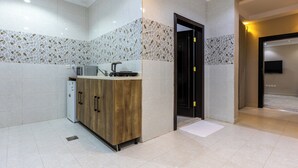 Une cuisine moderne avec des meubles en bois, un four à micro-ondes et une bouilloire.