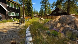 A residential area with a stone pathway, wooden deck, and a large rock. - Hot tub + Pool Table + Good Vibes (South Lake Tahoe)
