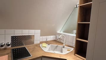 A kitchen with a sink, countertop, and cabinets.
