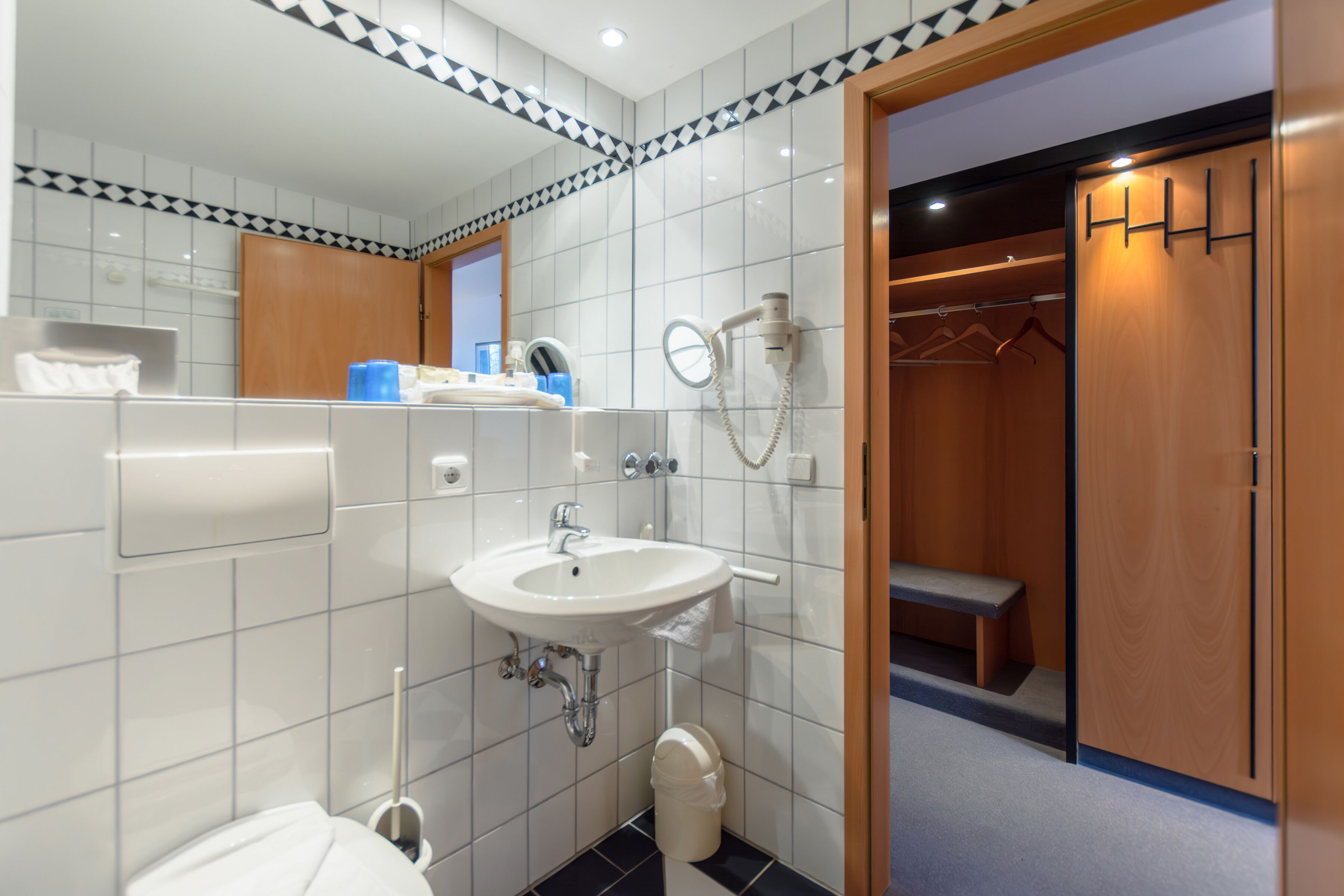 A modern bathroom with a sink, mirror, and shower.