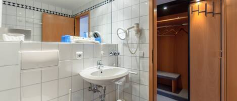 A modern bathroom with a sink, mirror, and shower.