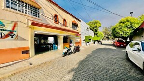 A street with a restaurant on the left and a parked car on the right.