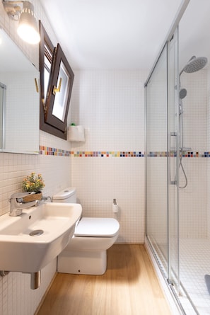 A bathroom with a sink, toilet, and shower.