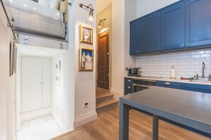 Una cocina moderna con armarios azules, encimera de madera y horno empotrado.
