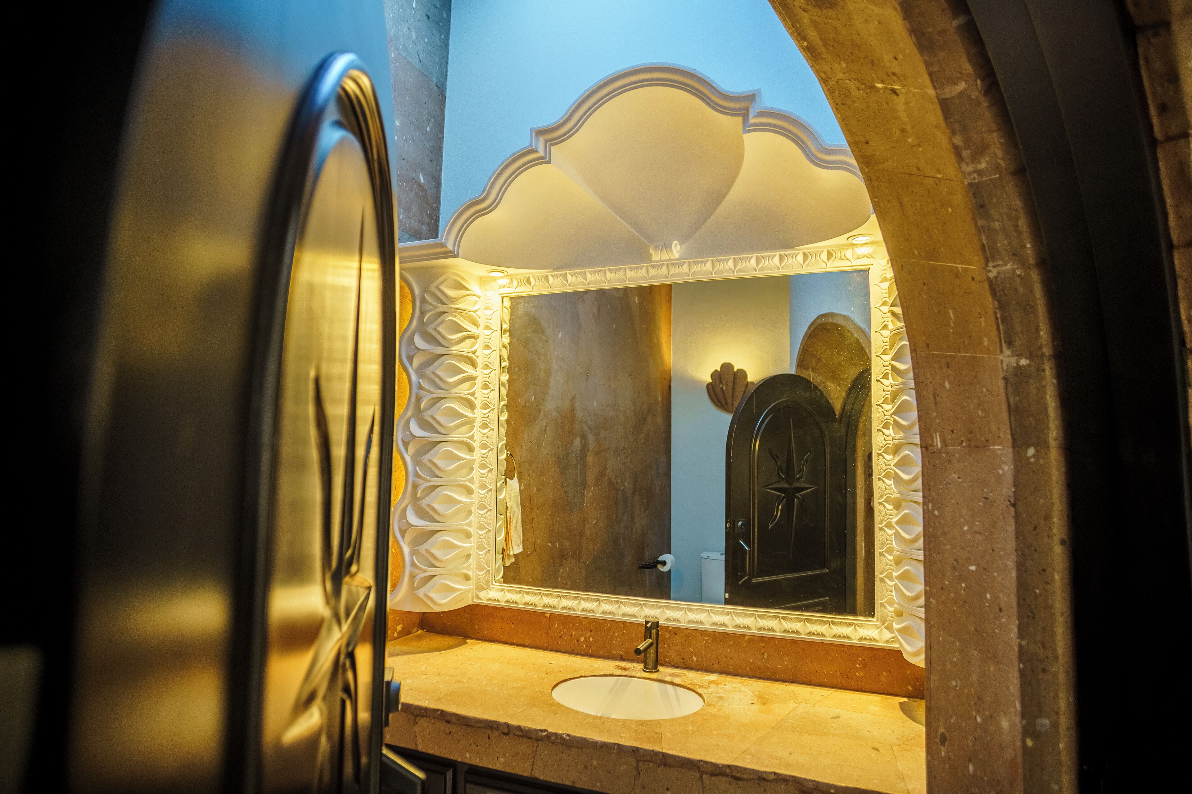 Un bagno con uno specchio grande, un lavandino e una porta.