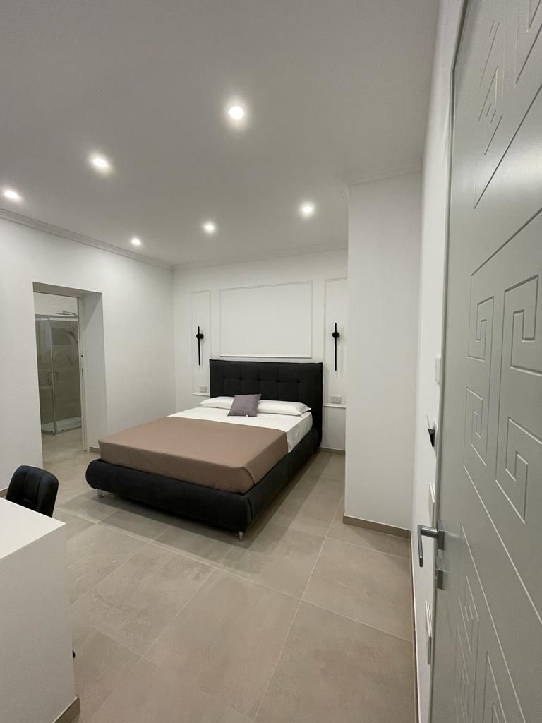 Ein modernes Schlafzimmer mit einem Bett, Nachttischen und einem Schreibtisch.