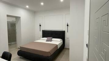 Ein modernes Schlafzimmer mit einem Bett, Nachttischen und einem Schreibtisch.