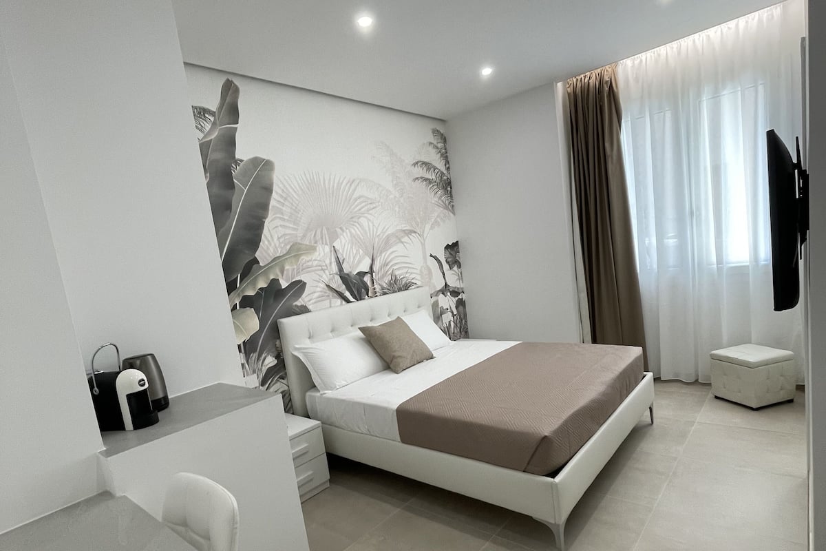 A modern bedroom with a bed, a desk, and a chair.