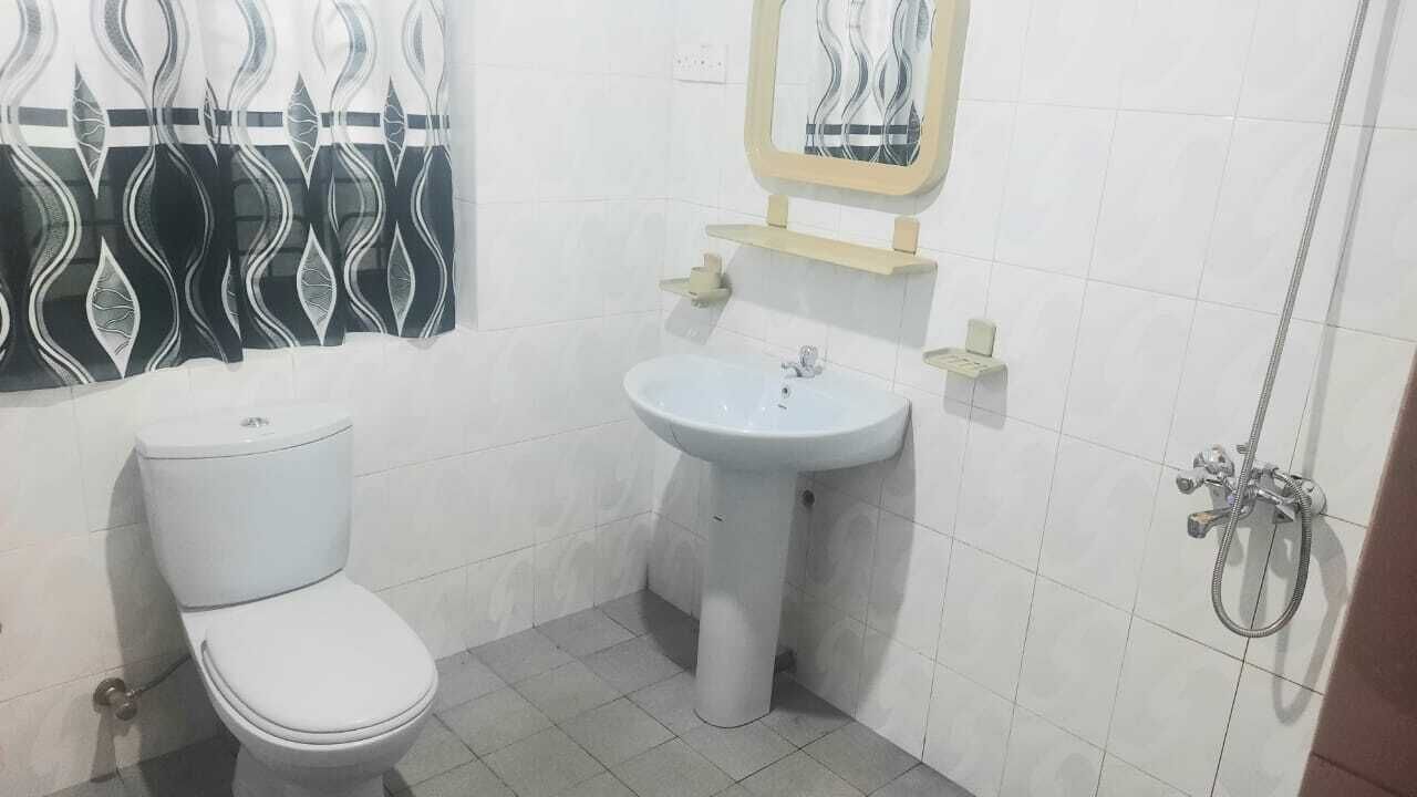 Un baño pequeño con inodoro, lavamanos y ducha.