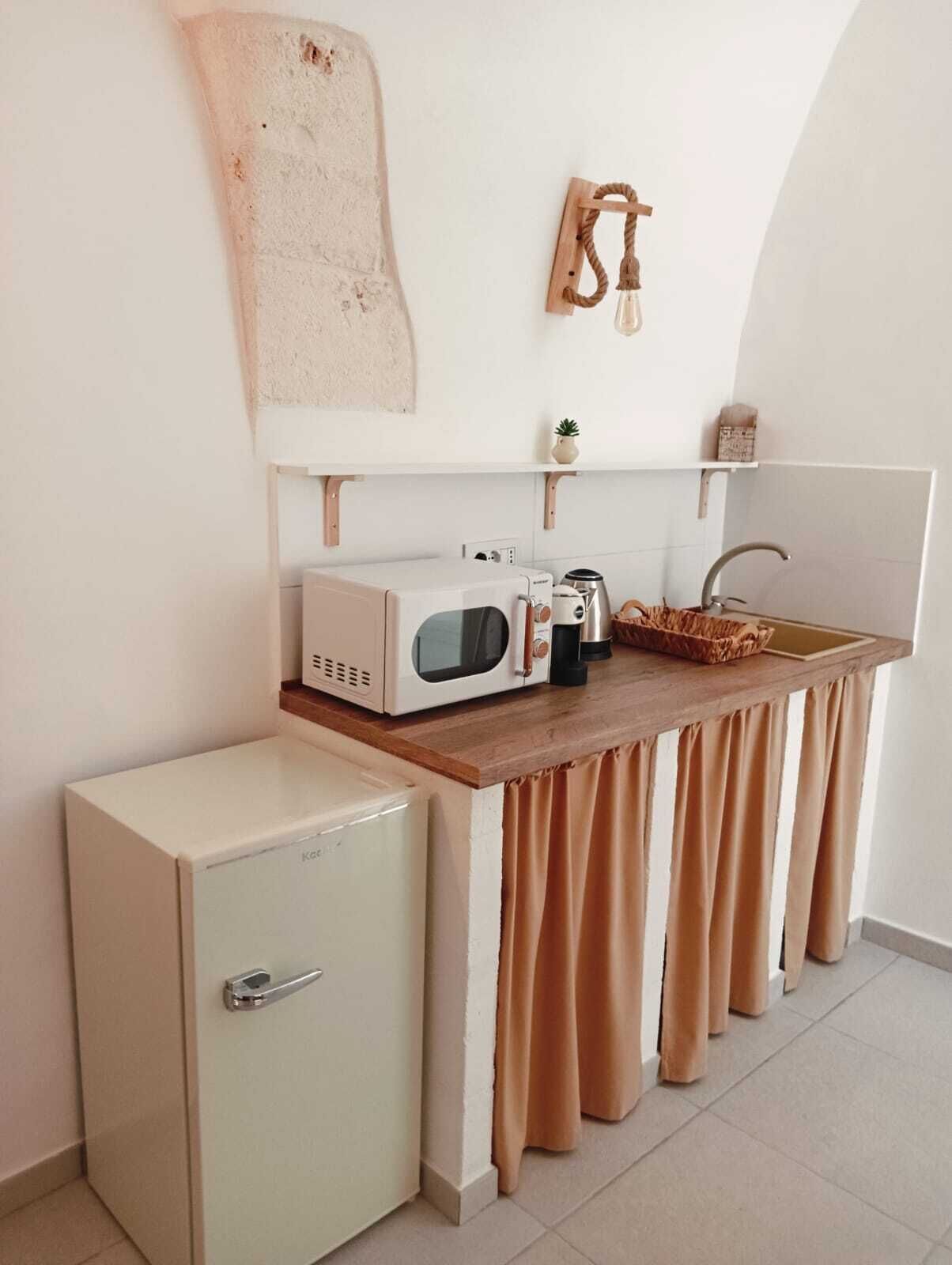A compact kitchenette with a microwave, coffee maker, and a small refrigerator.