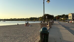 A beach with a trash can and a lamp post.
