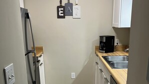 A compact kitchen with a refrigerator, a coffee maker, and a sink. - Beautiful Condo in Ocean Creek (Horry County)